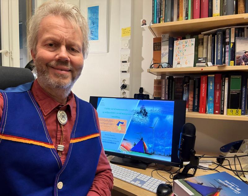 Mann, smiler, ser inn i kamera.